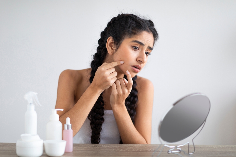 Woman feels frustrating with pimple on her face